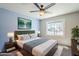 Bedroom featuring light blue walls, stylish bedding, a ceiling fan, and large window at 7519 N 23Rd Ave, Phoenix, AZ 85021