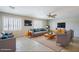 Bright living room featuring tile flooring, plantation shutters, modern furnishings, and plenty of natural light at 7519 N 23Rd Ave, Phoenix, AZ 85021