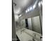 Bright bathroom with double vanity and updated light fixtures at 14727 W Pasadena Ave, Litchfield Park, AZ 85340
