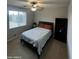 Bright bedroom with a queen-size bed, bookshelf, and large window at 14727 W Pasadena Ave, Litchfield Park, AZ 85340