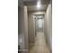 Long hallway with tile flooring and access to bedrooms at 14727 W Pasadena Ave, Litchfield Park, AZ 85340