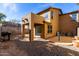 Backyard patio area featuring gravel, desert landscaping and a covered patio with access to the home at 18409 W Dawn Dr, Surprise, AZ 85374