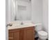 A clean half bathroom with wood cabinets and a white sink at 18409 W Dawn Dr, Surprise, AZ 85374