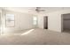 Carpeted bedroom with a ceiling fan, many windows and several doorways at 18409 W Dawn Dr, Surprise, AZ 85374