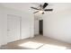 This carpeted bedroom features a ceiling fan and sliding-door closet at 18409 W Dawn Dr, Surprise, AZ 85374