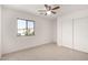 This carpeted bedroom features a ceiling fan and sliding-door closet at 18409 W Dawn Dr, Surprise, AZ 85374
