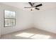 Bright carpeted bedroom with a large window and ceiling fan at 18409 W Dawn Dr, Surprise, AZ 85374