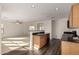 Open kitchen featuring an island with a sink and black countertops extending into the living area at 18409 W Dawn Dr, Surprise, AZ 85374