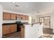 Well-equipped kitchen with wooden cabinetry, breakfast bar, and stainless-steel microwave at 18409 W Dawn Dr, Surprise, AZ 85374