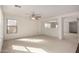 Bright and airy living room with neutral carpet, large windows and modern ceiling fan at 18409 W Dawn Dr, Surprise, AZ 85374