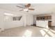 Open-concept living area showcases neutral carpet and seamless flow to the kitchen and dining spaces at 18409 W Dawn Dr, Surprise, AZ 85374