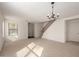 Open living room with neutral carpeting, staircase and abundant natural light from multiple windows at 18409 W Dawn Dr, Surprise, AZ 85374