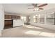 Spacious living room with neutral carpet, ceiling fan, and convenient access to kitchen area at 18409 W Dawn Dr, Surprise, AZ 85374