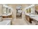 Double vanity bathroom with large mirrors and access to Primary bedroom at 32159 N 127Th Dr, Peoria, AZ 85383