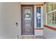 Elegant dark brown front door with glass panels and a wreath at 32159 N 127Th Dr, Peoria, AZ 85383