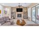 Living room with stone fireplace, built-in shelving and access to patio at 32159 N 127Th Dr, Peoria, AZ 85383