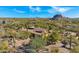 Aerial view showing a house nestled in a desert landscape with mountains in the background at 35035 N Whileaway Rd, Carefree, AZ 85377