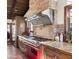 Gourmet kitchen with red range, custom backsplash, and wood cabinetry at 35035 N Whileaway Rd, Carefree, AZ 85377