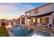 Sunset view of a luxurious backyard pool and patio area with fire pit at 3750 E Earll Dr, Phoenix, AZ 85018