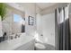 Clean bathroom with a white vanity, bathtub, and gray shower curtain at 3750 E Earll Dr, Phoenix, AZ 85018