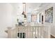Upstairs hallway with white railings, modern light fixtures, and artwork at 3750 E Earll Dr, Phoenix, AZ 85018