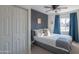 Guest bedroom with a gray bed and blue curtains at 8502 E Catalina Dr, Scottsdale, AZ 85251