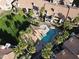 Aerial view of a condo community pool and surrounding buildings with red tile roofs and green lawns at 930 N Mesa Dr # 2073, Mesa, AZ 85201
