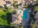 Aerial view of a landscaped community pool, sun loungers, and surrounding buildings with lawns at 930 N Mesa Dr # 2073, Mesa, AZ 85201