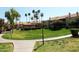Lush community courtyard with vibrant green grass, mature palm trees, sidewalks, and Spanish-style buildings at 930 N Mesa Dr # 2073, Mesa, AZ 85201