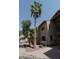A two-story apartment building with red rock landscaping and mature palm trees in a sunny, well-maintained community at 930 N Mesa Dr # 2073, Mesa, AZ 85201