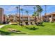 Landscaped condo exterior with lush green lawn, mature palm trees, and building facade at 930 N Mesa Dr # 2073, Mesa, AZ 85201