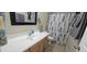 Well-lit bathroom features a vanity with modern fixtures and a decorative shower curtain for a clean aesthetic at 11232 N 152Nd Ln, Surprise, AZ 85379