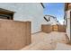 Empty backyard featuring a block wall and a gate with view of neighboring homes at 14670 W Sand Hills Rd, Surprise, AZ 85387