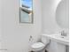 Bright bathroom featuring a pedestal sink, modern fixtures and a elongated toilet at 14670 W Sand Hills Rd, Surprise, AZ 85387
