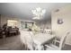 Bright dining room features a large table with seating for six and a beautiful chandelier at 14818 N 103Rd Ave, Sun City, AZ 85351