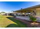 Exterior view showing covered patio and grassy area at 14818 N 103Rd Ave, Sun City, AZ 85351