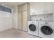 Bright laundry room features washer, dryer, cabinets, and storage space at 14818 N 103Rd Ave, Sun City, AZ 85351