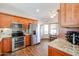 Kitchen boasts granite countertops, wood cabinets, and stainless steel appliances at 17561 N Saddle Ridge Dr, Surprise, AZ 85374