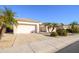 Single-story home with palm trees, landscaping, and a two-car garage at 17824 W Addie Ln, Surprise, AZ 85374