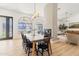 Dining area with a large farmhouse table, black chairs, and views to the pool at 18335 W Orangewood Ave, Waddell, AZ 85355