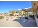 Landscaped backyard with a covered patio and grill at 20516 N Vermillion Cliffs Dr, Surprise, AZ 85387