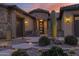 Welcoming entryway with stone accents and landscape lighting at 5841 W Bushwood Ct, Florence, AZ 85132