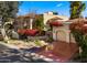 Spanish style home with red flowers, two car garage, and a large driveway at 7500 E Mccormick Pkwy # 11, Scottsdale, AZ 85258