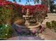 Ornate stone fountain with colorful flowers and landscaping at 7500 E Mccormick Pkwy # 11, Scottsdale, AZ 85258