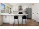 Modern kitchen with white shaker cabinets, quartz countertops, and island at 8375 E Indian School Rd, Scottsdale, AZ 85251