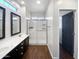 Bathroom with double sinks, dark vanity, and a walk-in shower at 10510 E Neville Ave, Mesa, AZ 85209