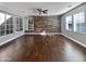Bright living area featuring wood-look floors and a rustic accent wall at 10510 E Neville Ave, Mesa, AZ 85209
