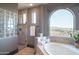 Spa-like bathroom with soaking tub, glass shower, and mountain views at 10532 N Crestview Dr, Fountain Hills, AZ 85268