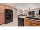Kitchen with wood cabinets, black appliances, and island at 10960 E Monte Ave # 125, Mesa, AZ 85209
