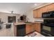 Open kitchen with island and black appliances at 10960 E Monte Ave # 125, Mesa, AZ 85209